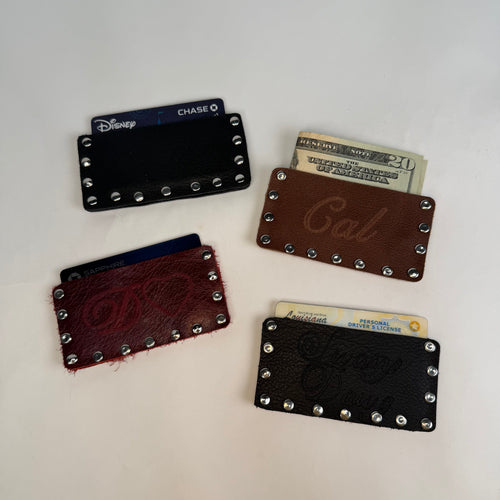 Collection of leather card holders with studded details on a white background